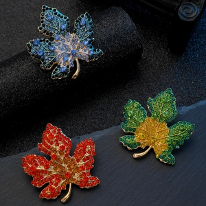 Macro detail of luxury maple leaf brooches with colorful rhinestones on stone base