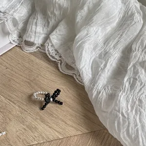 Detail of beaded S925 silver ring with black bead bow and contrast texture