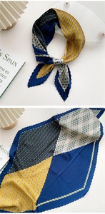 Detailed view of pleated silk scarf featuring geometric stripes, polka dots and plaid patterns