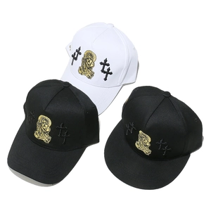Detail of cross and gold embroidery on black and white cotton baseball caps