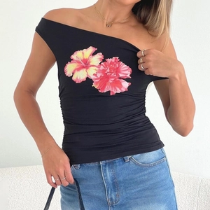 Détail du t-shirt noir à épaules dénudées avec imprimé floral d'hibiscus sur la poitrine
