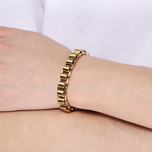 Détail d'un bracelet gourmette doré en acier inoxydable porté au poignet d'un mannequin