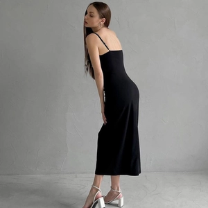 Détail de la robe longue noire à dos nu montrant le tissu satiné et la coupe ajustée