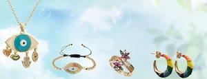 Detail of bohemian gold jewelry set featuring evil eye pendants and rainbow zircon accents