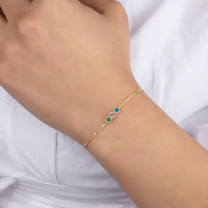 Detail view of dainty gold titanium steel bracelet with three colored gemstones