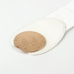 Close-up of white elastic waist belt with gold round buckle and sunburst texture