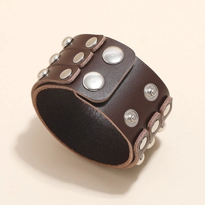 Close-up of brown punk leather bracelet featuring three rows of polished metal rivets