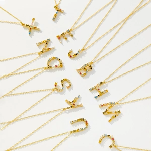 Gold-plated S925 silver necklaces with colorful gemstone letter pendants on white background