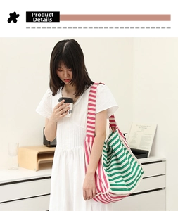 Dettaglio di una grande borsa tote in tela a righe verdi e rosa, stile casual da donna