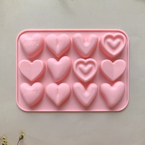Pink 12-cavity silicone heart mold featuring happy lettering and textured designs for DIY baking