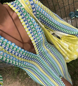 Detail of bohemian crochet dress featuring a deep V-neck and multi-color knit patterns
