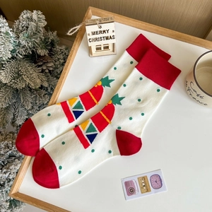Chaussettes de Noël rouges et vertes festives avec motifs élan et Père Noël sur un bureau