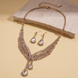 Detailed view of teardrop rhinestone necklace and matching earrings on stone prop