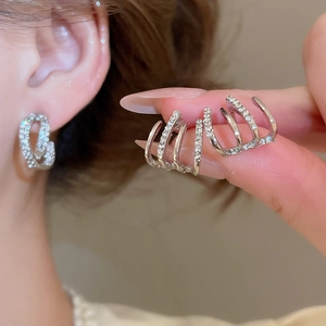 Macro shot of double-layered silver C-shaped earrings with micro-paved cubic zirconia crystals