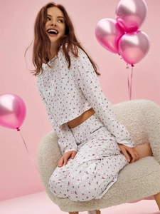 Détail de l'imprimé floral rose sur pyjama en coton blanc à col rond et manches longues