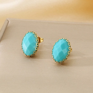 Detailed macro view of oval turquoise glass stud earrings with gold flower basket claws