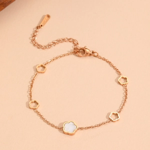 Rose gold stainless steel bracelet featuring five cutout flower charms with shell inlay