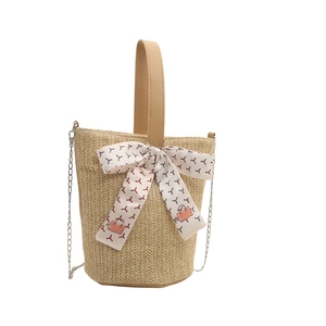 Minimalist straw bucket tote with silk scarf decoration and metal chain strap