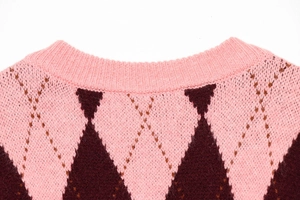 Detail of pink and burgundy argyle knit sweater neckline with ribbed collar finish