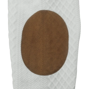 Detail of white knit diamond texture and brown oval suede patch with fine stitching