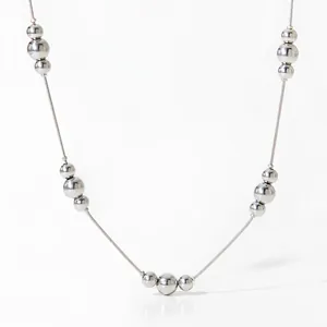 Close-up of a silver beaded necklace with mirror-finish spheres and a delicate chain