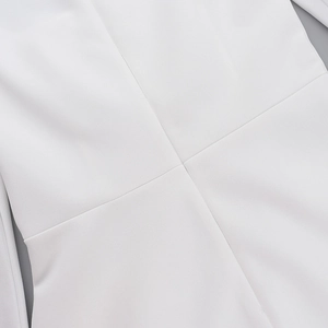 Gros plan sur les coutures précises et la texture du tissu tissé d'une robe blanche