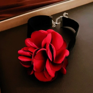 Close-up of a red satin rose flower choker with black velvet band and metal extension chain