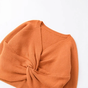 Maglione in maglia arancione brillante con nodo a torsione sul davanti ed elegante scollo a V
