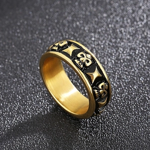 Macro shot of gold punk skull ring with black relief engraving and star patterns
