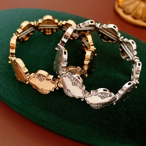 Gros plan de bracelets extensibles baroques en or et argent sur velours