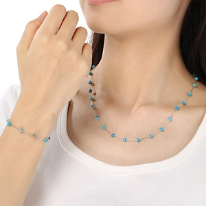 Detailed view of minimalist stainless steel necklace and bracelet set with blue glass beads