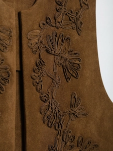Close-up of intricate 3D floral embroidery on dark brown suede waistcoat vest