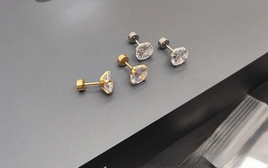 Detailed macro view of 316L stainless steel stud earrings with gold and silver finishes