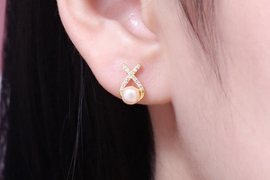 Close-up of S925 silver cross earrings with freshwater pearls and sparkling zircons