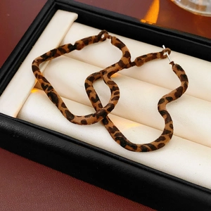 Macro shot of heart-shaped leopard print earrings with velvet texture in a black jewelry box