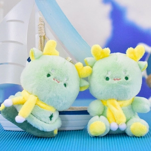 Pair of cute green plush dragon dolls with yellow scarves and antlers beside a toy boat