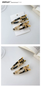 Detailed view of tortoiseshell cat-shaped hair clips with gold accents in a two-piece set