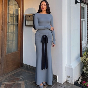 Detailed view of blue-grey floor-length dress featuring waist pleats and a black bow belt