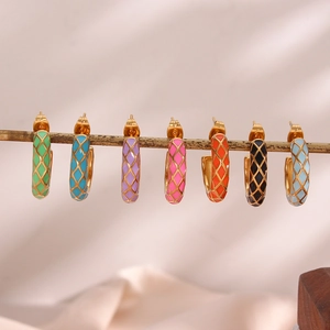 Close-up of gold-plated U-shaped earrings with colorful enamel and lattice patterns