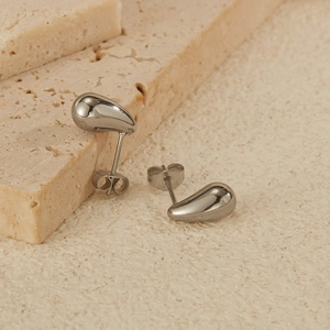 Detailed macro shot of silver waterdrop earrings with a high-polished metallic finish