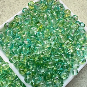Vue macro de perles en verre dégradé vert et jaune avec une finition polie claire