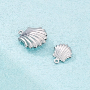 Polished silver stainless steel seashell pendants in two sizes on blue textured background