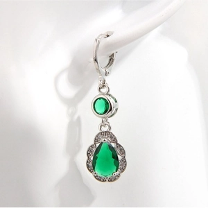 Elegant silver-toned cloud earrings with emerald green zircon pendants worn by model