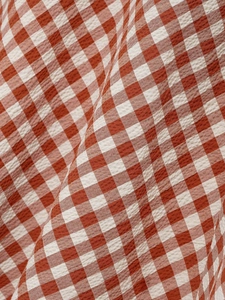 Detail of red and white checkered seersucker fabric with textured woven pattern