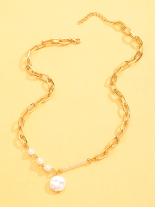 Detailed view of a gold chunky chain necklace with faux pearls and a round pendant