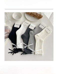 Detailed flat lay of five colors ribbon bow mid-calf socks with ribbed knit texture