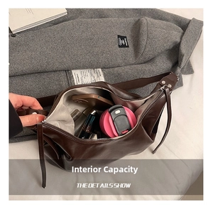 Internal capacity of large brown leather hobo bag showing phone and cosmetics