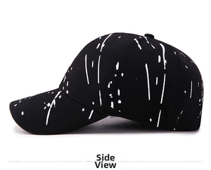 Side view detail of a black graffiti baseball cap with white ink splash print pattern