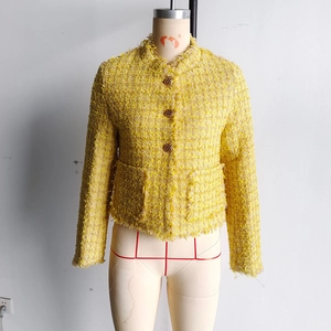 Gros plan sur le tissu en tweed jaune avec boutons dorés et bords effilochés