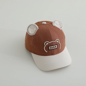 Détail de la casquette bébé avec oreilles d'ours 3D et panneaux contrastés marron et beige